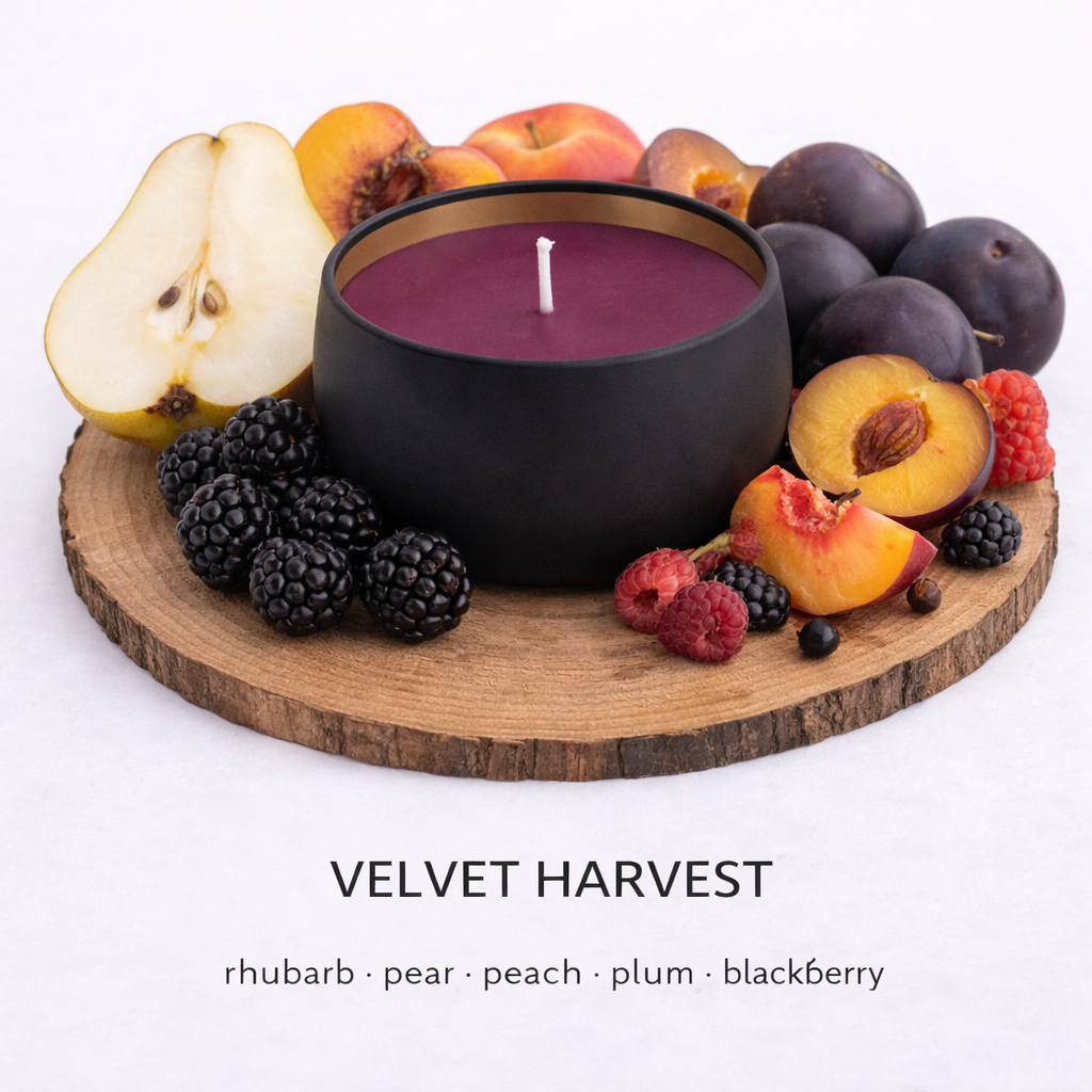 Velvet Harvest soy wax candle with plum purple wax in matte black tin, surrounded by pear, peach, plum and blackberry, luxury handmade candle UK