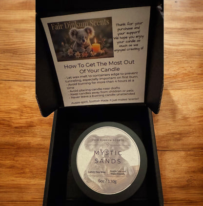 Inside view of box showing stylish black tin, lid and label. As well as candle care card. 