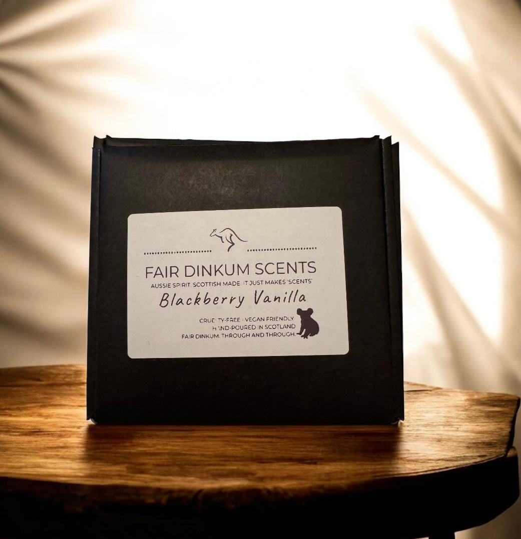 Black packaging with a label for 'Fair Dinkum Scents Blackberry Vanilla' on a wooden surface.